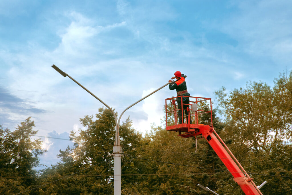 Bucket with Maintenance Worker Working on a Parking Lot Lighting Pole